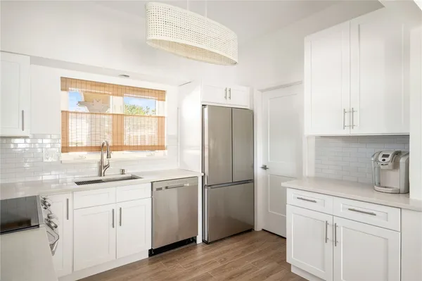 a kitchen with a refrigerator sink and cabinets