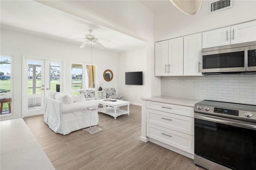 5045 Harmony Circle, Unit 102 Vero Beach, FL 32967 - Photo 18 of 28 a living room with furniture flat screen tv and view