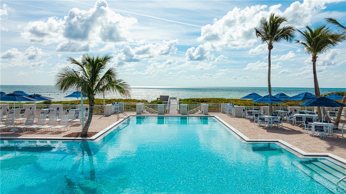 5045 Harmony Circle, Unit 102 Vero Beach, FL 32967 - Photo 22 of 28 a view of a swimming pool with a lawn chairs