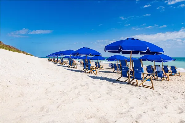 a view of chairs and tables with umbrellas in patio
