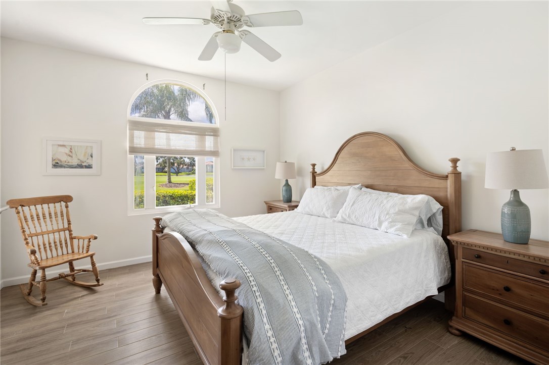 5045 Harmony Circle, Unit 102 Vero Beach, FL 32967 - Photo 5 of 28 a bedroom with a bed and a chandelier