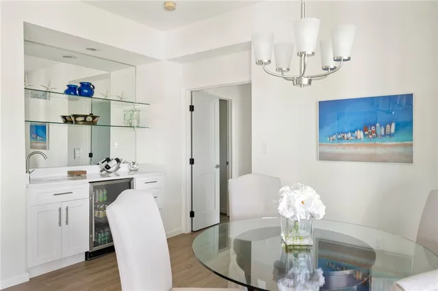 a dining room with wooden floor a chandelier a wooden table and chairs