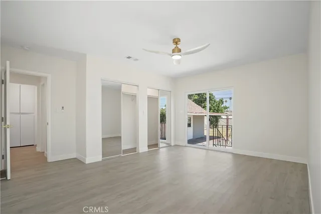 a view of a livingroom with wooden floor and a ceiling fan
