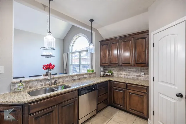 a bathroom with a granite countertop sink a large mirror and a window