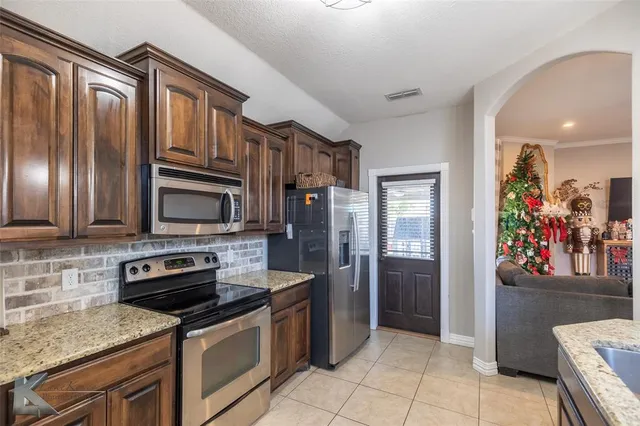 a view of a dining room with furniture a potted plant and wooden floor