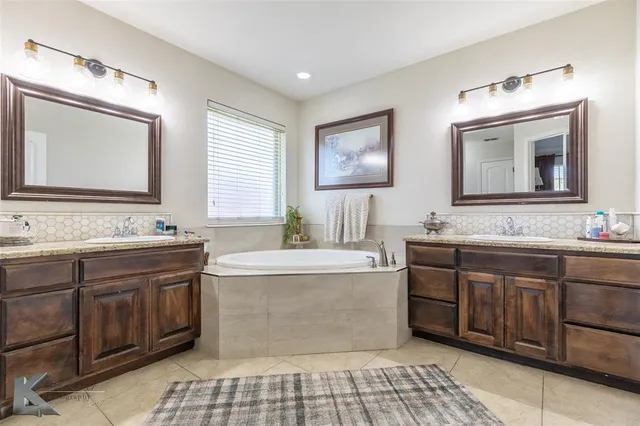 a bathroom with a tub sink and mirror