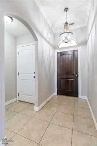 a view of a livingroom with a chandelier fan and refrigerator