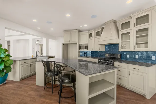 a view of a room with wooden floor ceiling fan and windows