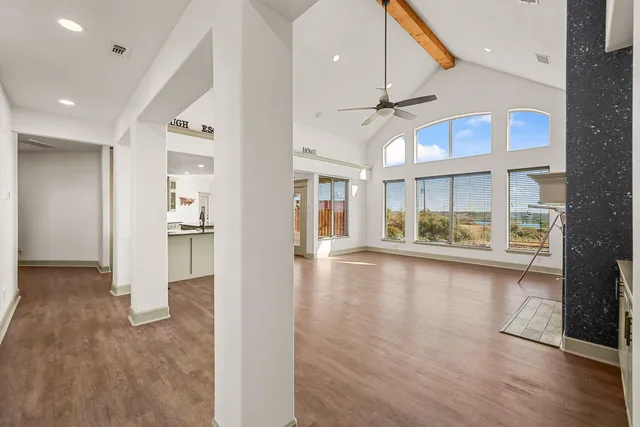 a view of an empty room with window and wooden floor
