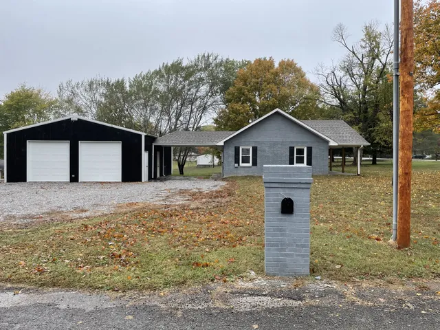a white house that has tree in front of it