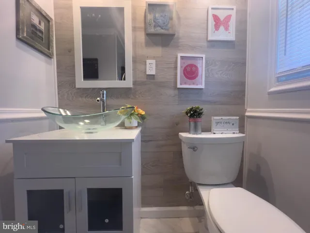 a bathroom with a toilet sink and mirror