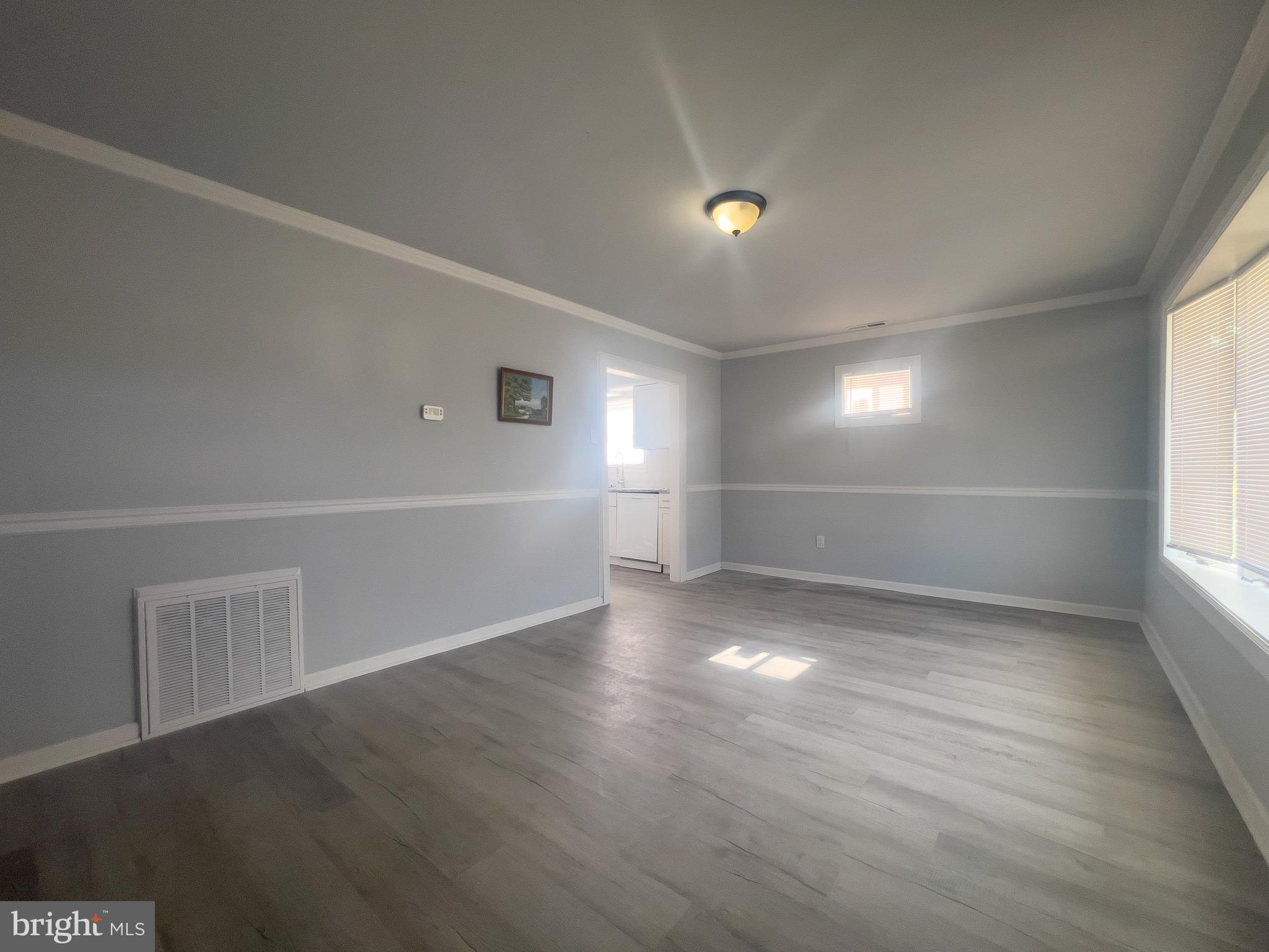 384 Windsor Drive Bellmawr, NJ 08031 - Photo 4 of 23 an empty room with wooden floor and windows