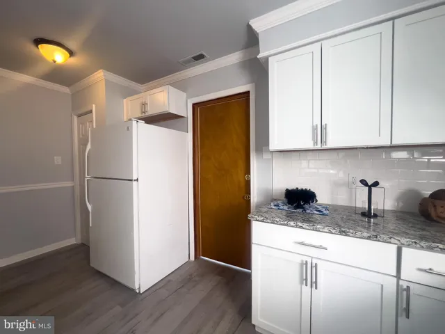 a kitchen with a refrigerator and a stove top oven