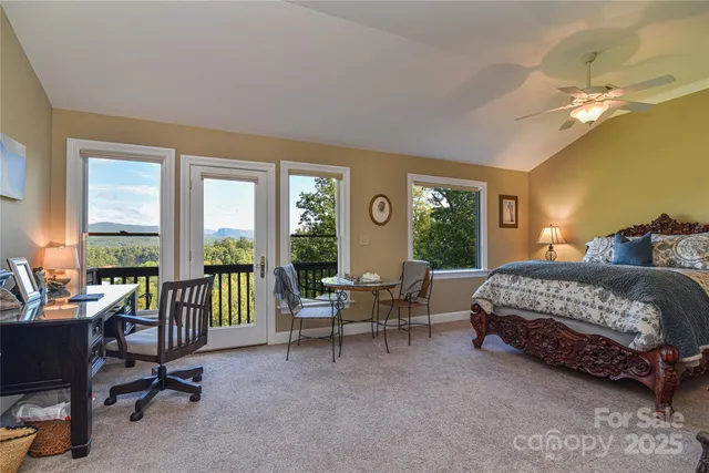 a bedroom with a bed and large windows