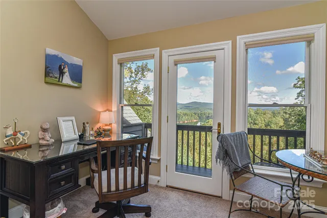 a view of a workspace with furniture and a window