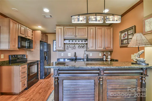 a kitchen with granite countertop a sink a counter top space and cabinets