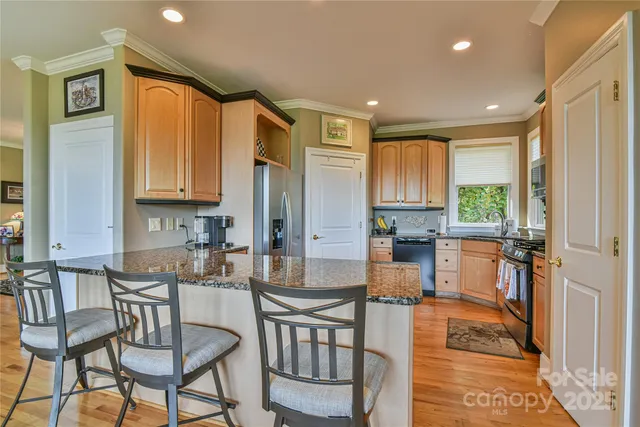 a kitchen with sink refrigerator dining table and chairs