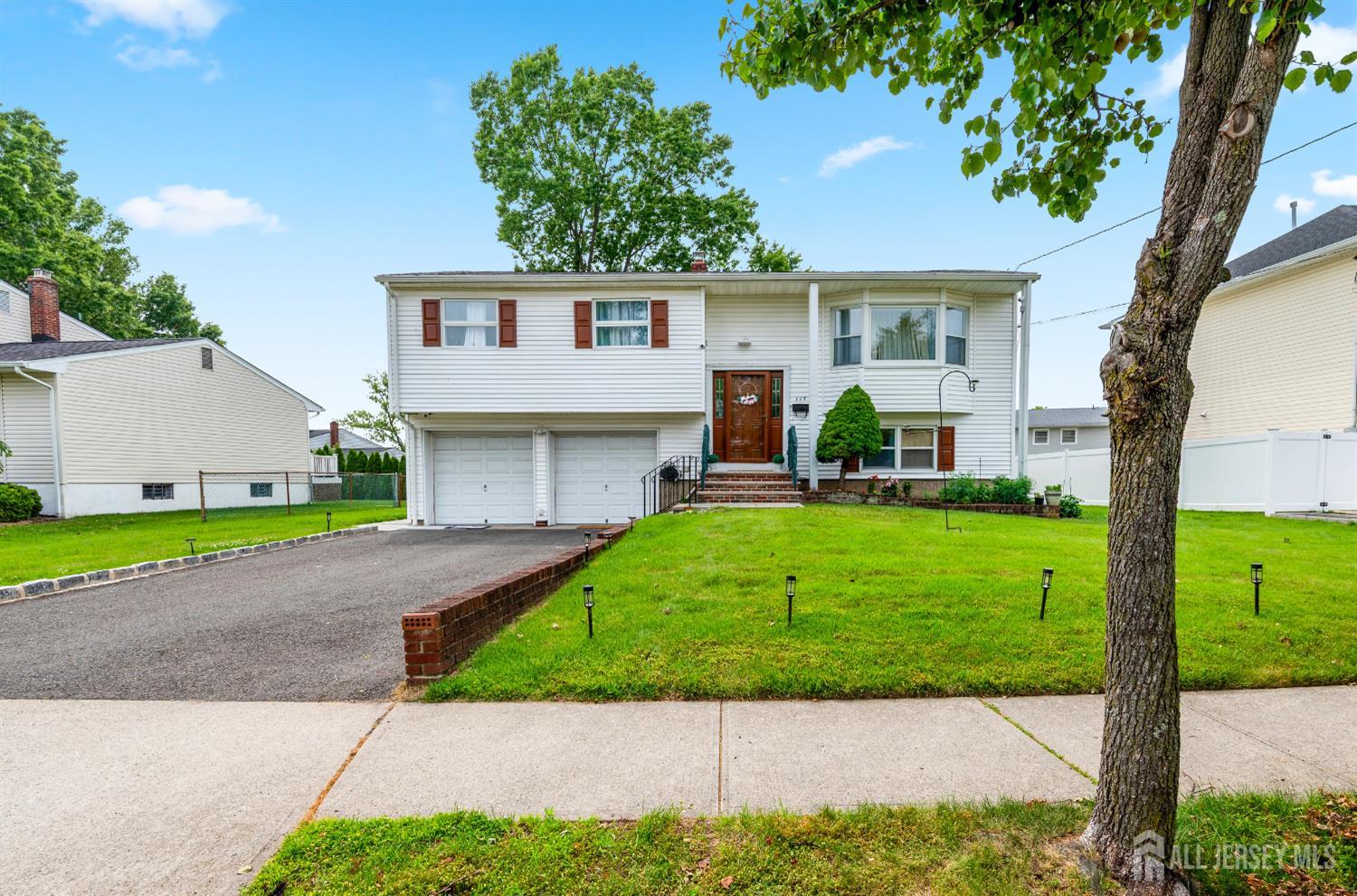 115 Vernon Way Port Reading, NJ 07064 - Photo 2 of 33 a front view of a house with a yard and garage