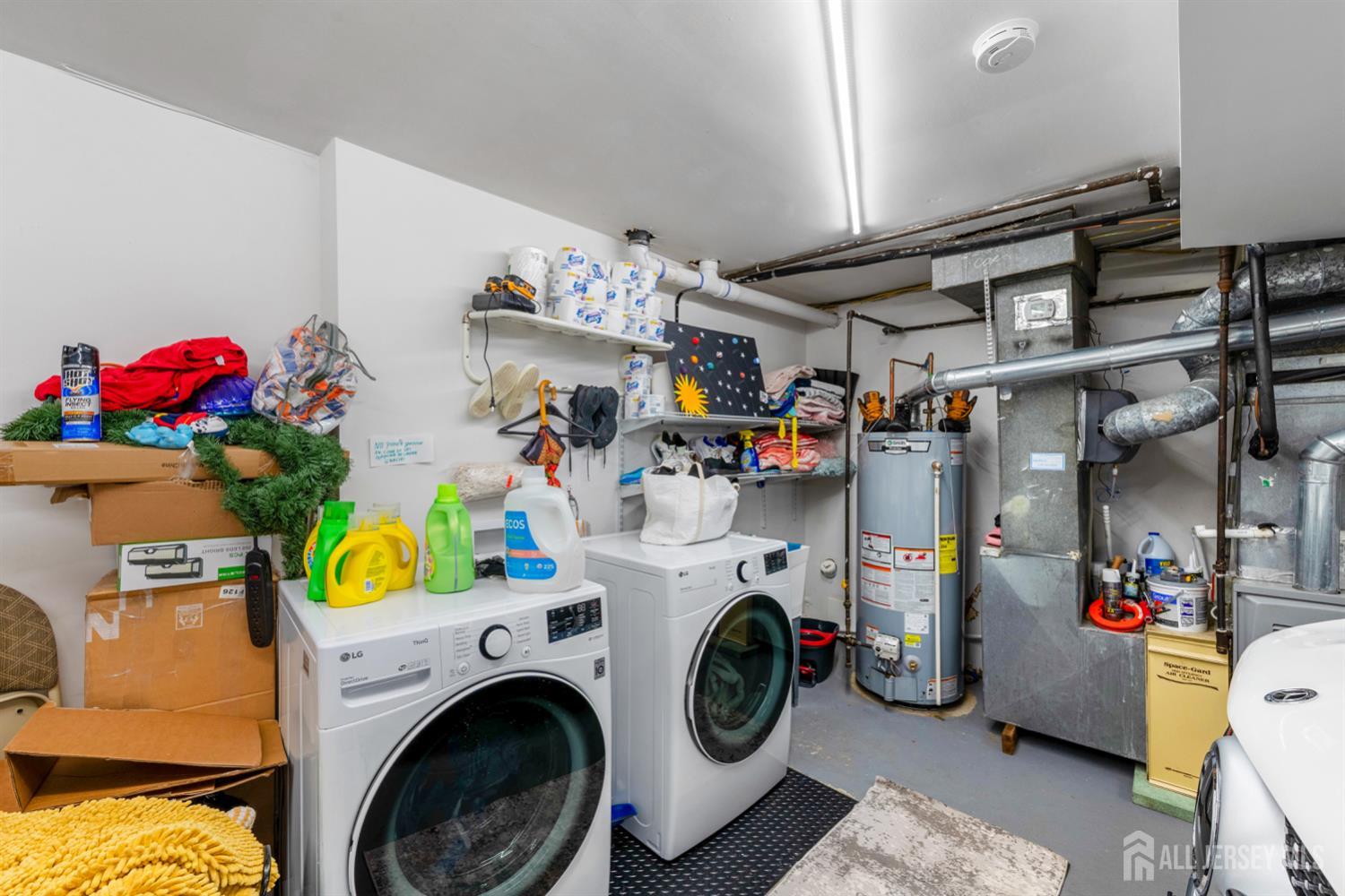 115 Vernon Way Port Reading, NJ 07064 - Photo 26 of 33 a utility room with fridge washing machine and a chandelier