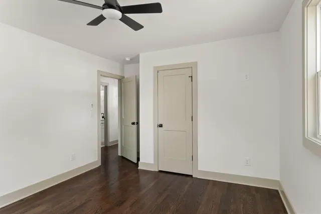 an empty room with wooden floor a ceiling fan and closet