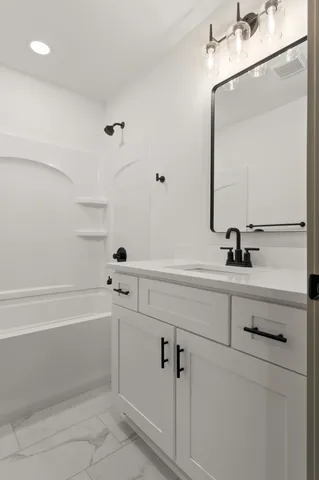 a bathroom with a sink a toilet a mirror and shower