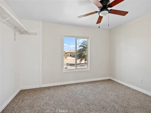 an empty room with a window and a fan