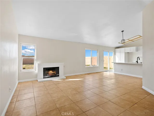 an empty room with windows and fireplace