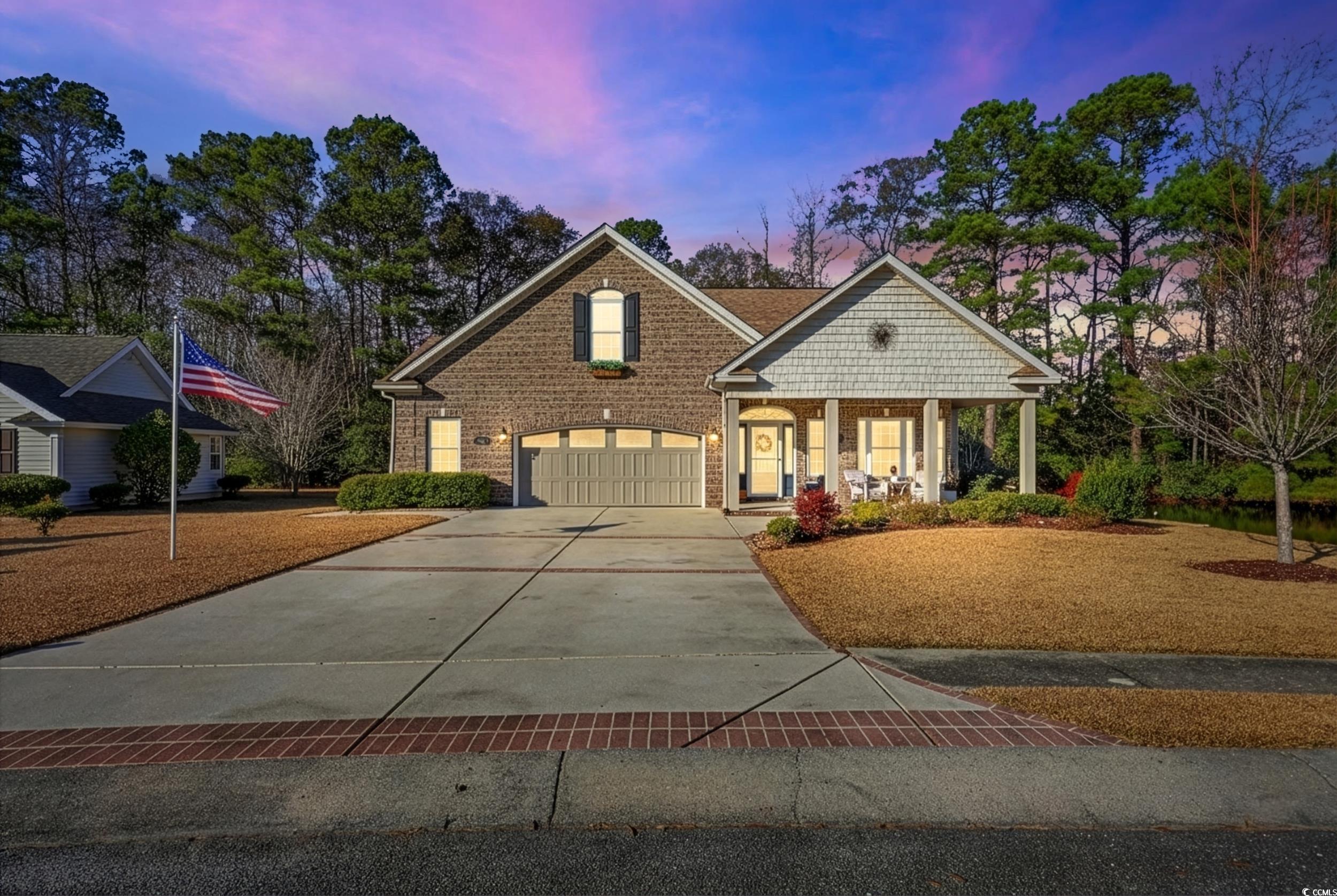 Craftsman house with covered porch, concrete driveway, a garage, and brick siding