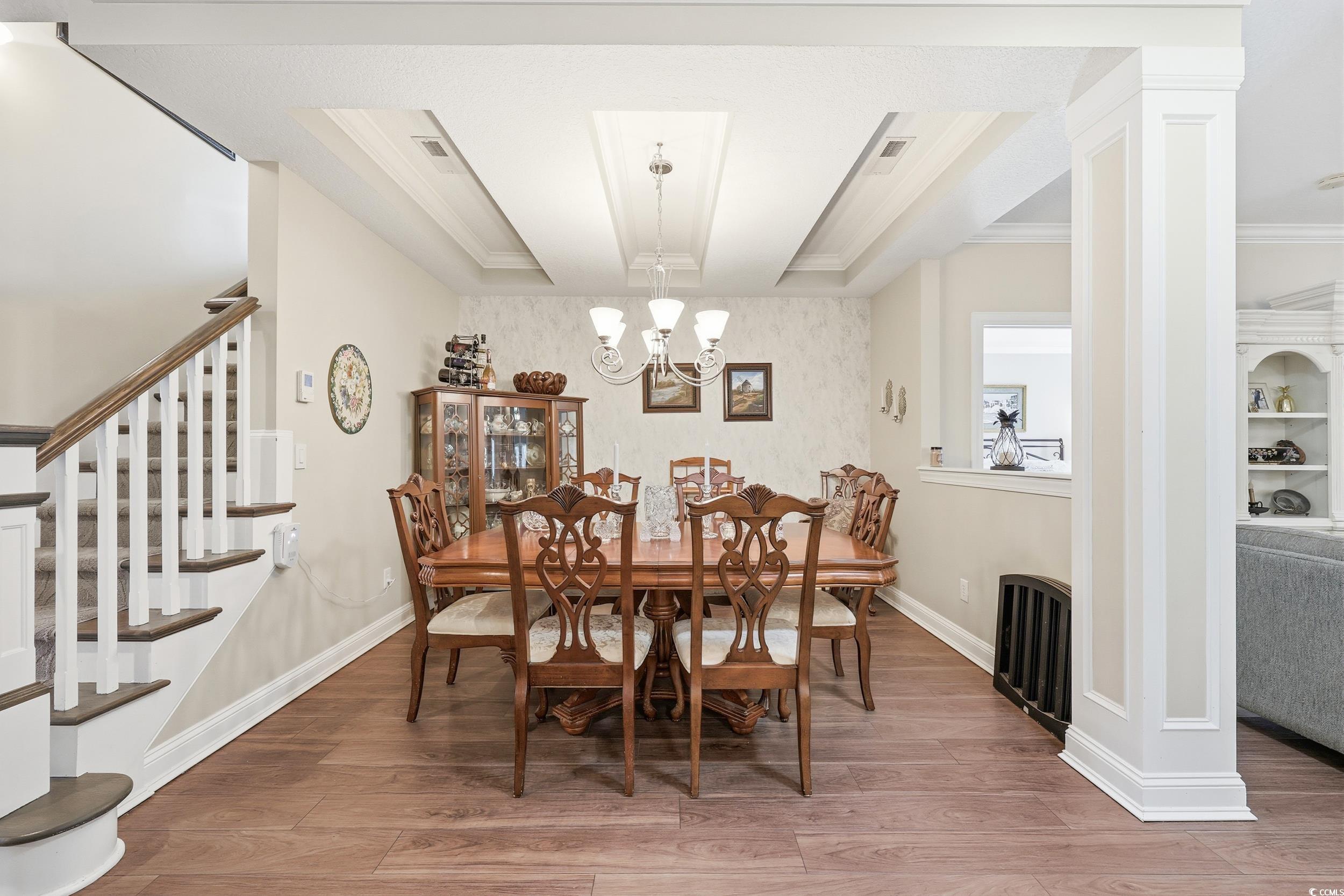 452 Deer Watch Circle Longs, SC 29568 - Photo 11 of 39 Dining room featuring light wood-type flooring, a chandelier, stairs, radiator, and crown molding