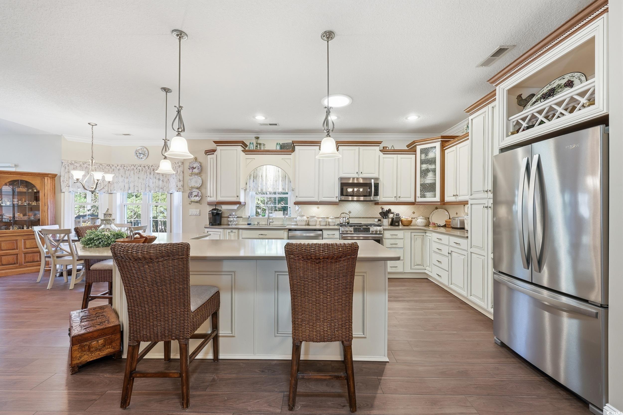 452 Deer Watch Circle Longs, SC 29568 - Photo 12 of 39 Kitchen with pendant lighting, appliances with stainless steel finishes, a kitchen island, dark wood-style floors, and a kitchen bar