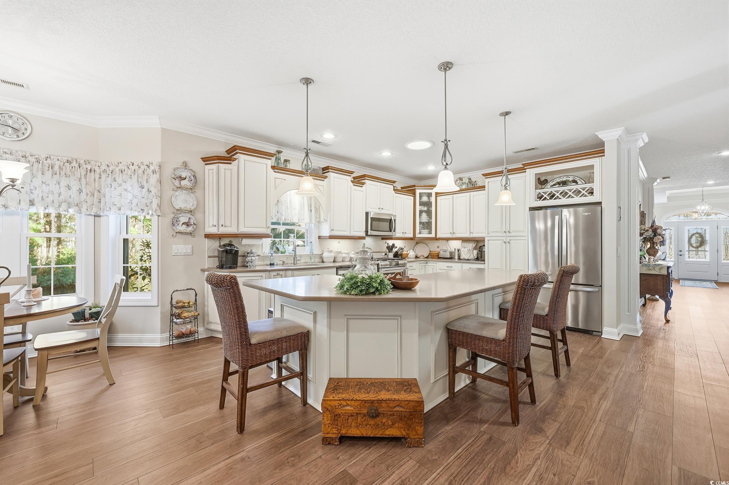452 Deer Watch Circle Longs, SC 29568 - Photo 13 of 39 Kitchen with a kitchen bar, decorative light fixtures, crown molding, a center island, and appliances with stainless steel finishes