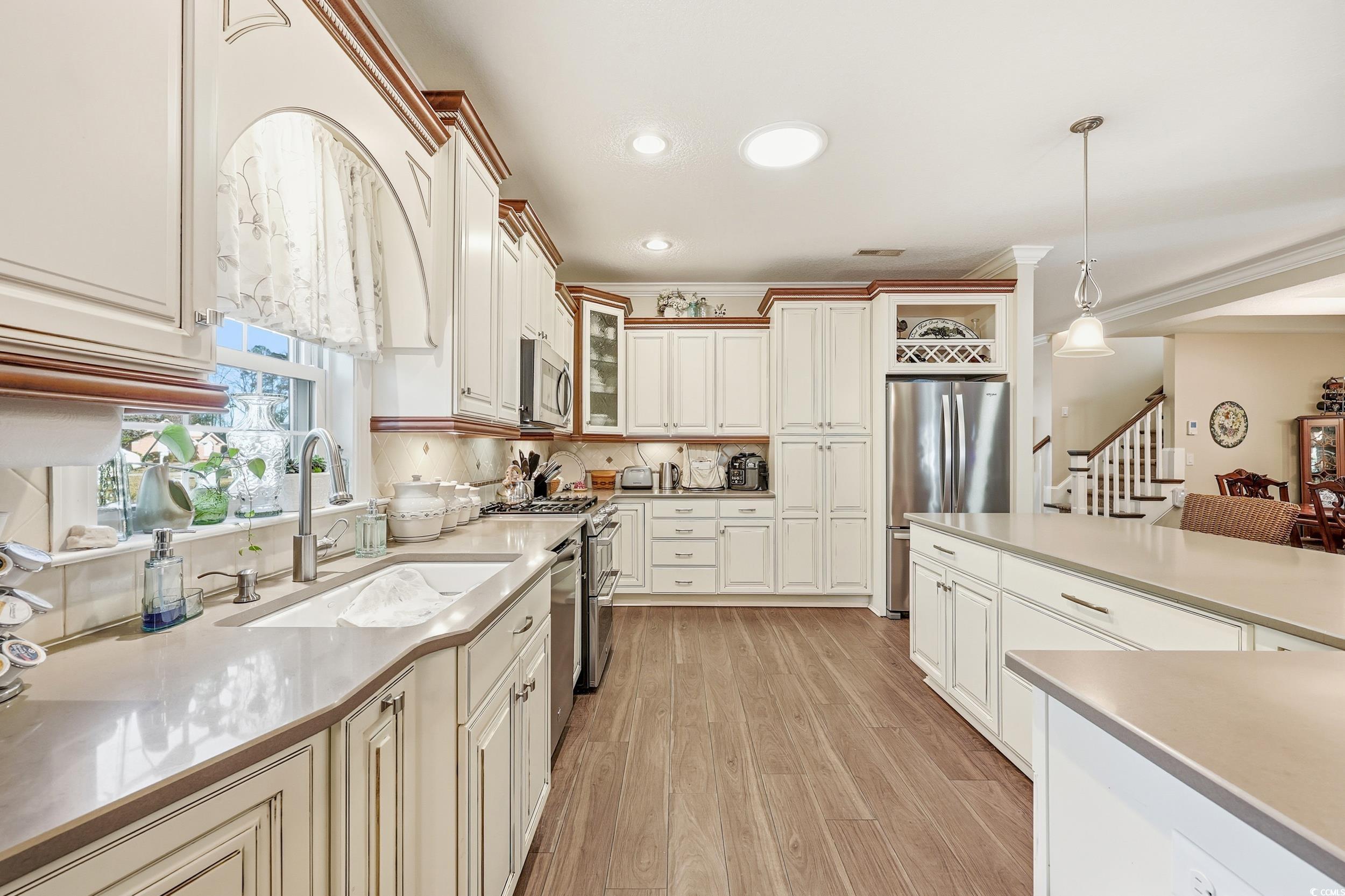 452 Deer Watch Circle Longs, SC 29568 - Photo 14 of 39 Kitchen featuring hanging light fixtures, glass insert cabinets, appliances with stainless steel finishes, recessed lighting, and light wood finished floors