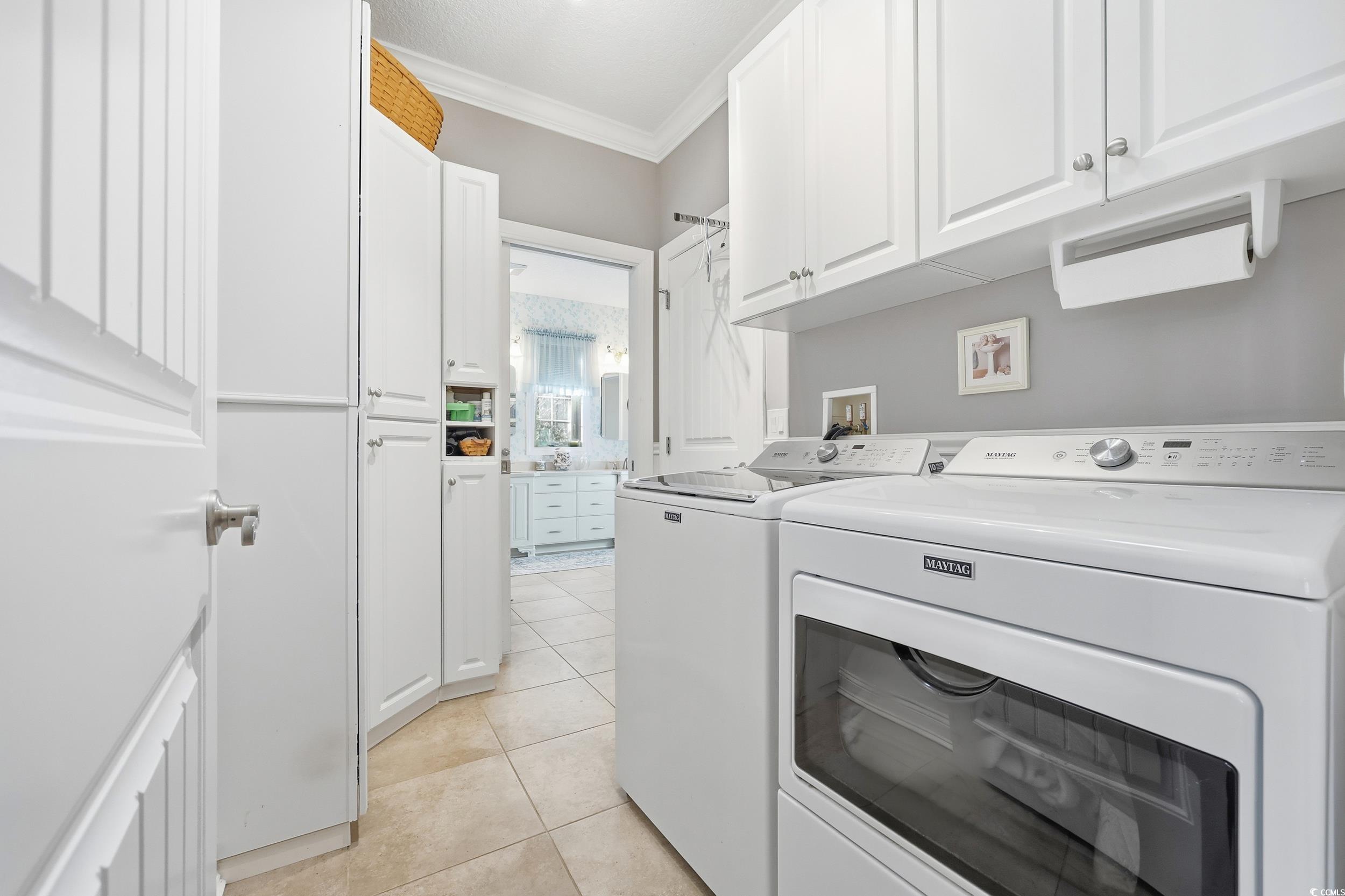 452 Deer Watch Circle Longs, SC 29568 - Photo 23 of 39 Washroom featuring cabinet space, crown molding, light tile patterned flooring, and separate washer and dryer