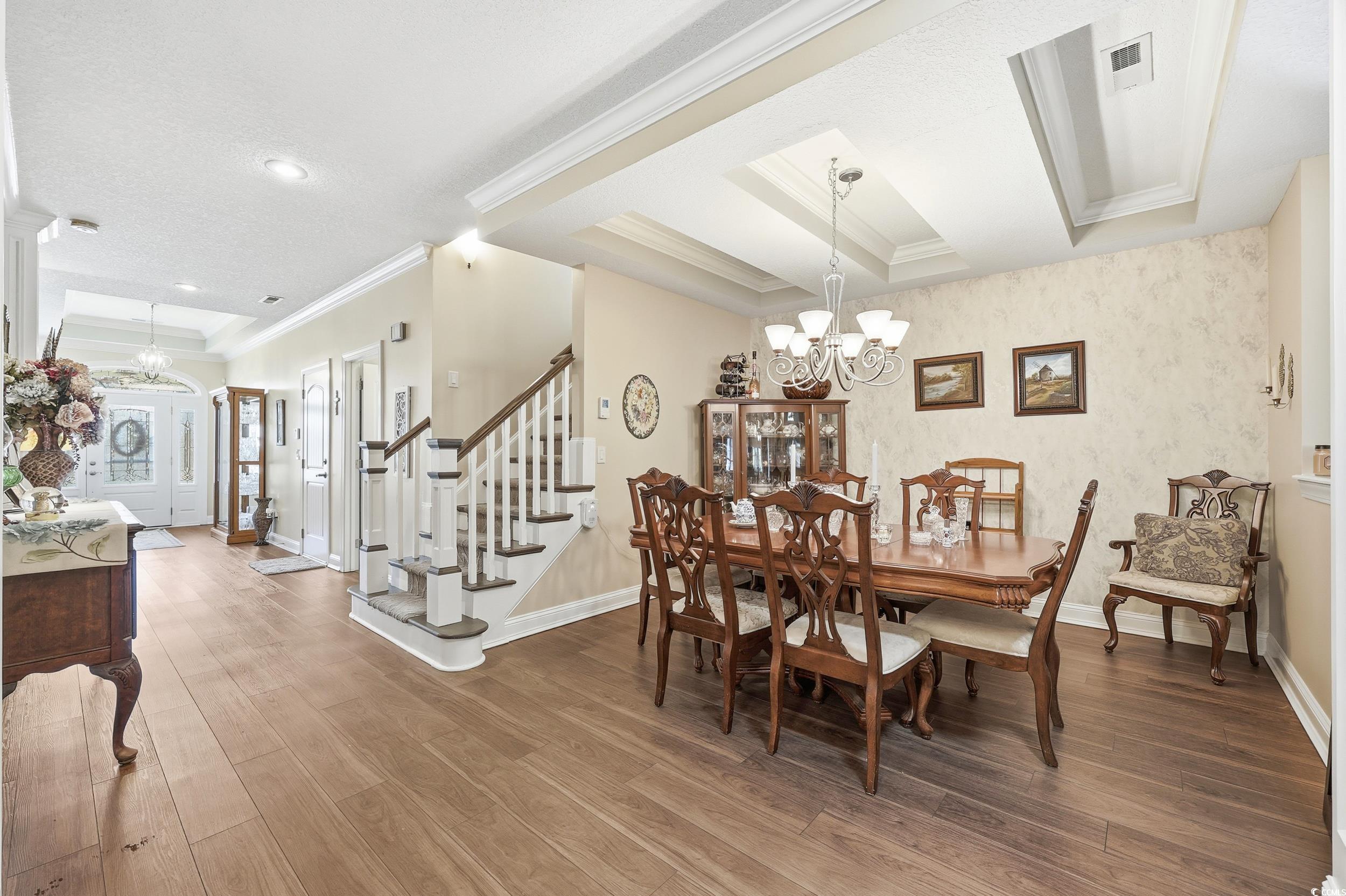 452 Deer Watch Circle Longs, SC 29568 - Photo 10 of 39 Dining space with a chandelier, wood-type flooring, crown molding, and stairway