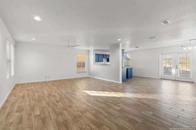 a view of empty room with wooden floor