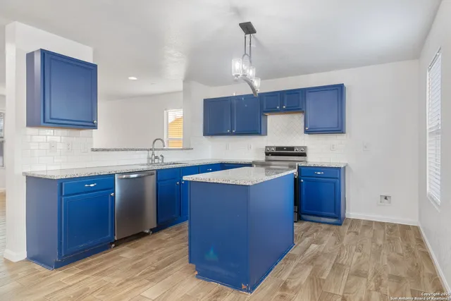a kitchen with granite countertop wooden cabinets and a sink