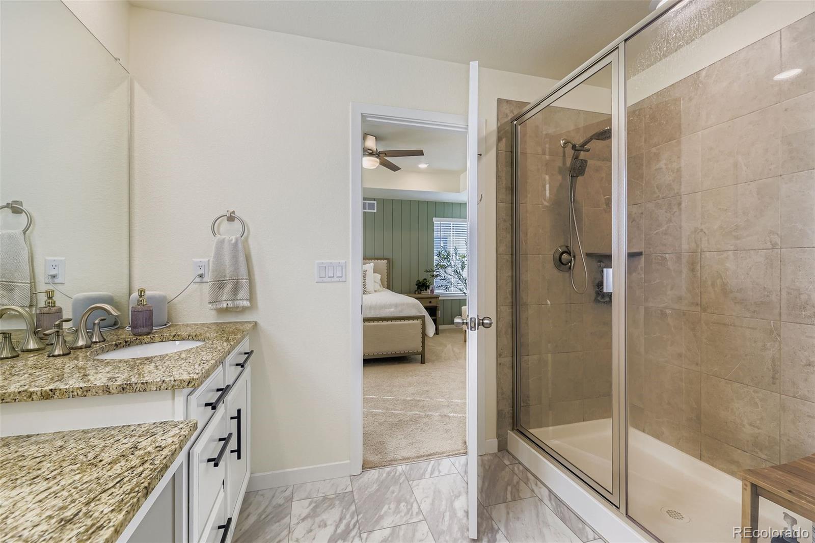 1126 Williams Loop Elizabeth, CO 80107 - Photo 22 of 50 a en suite bathroom with a granite countertop sink and a mirror