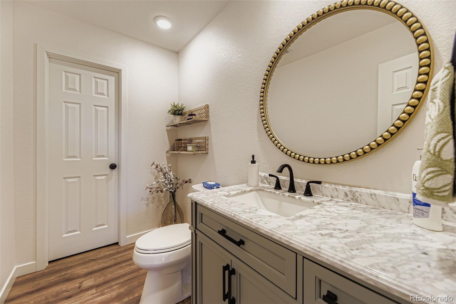 1126 Williams Loop Elizabeth, CO 80107 - Photo 35 of 50 a bathroom with a granite countertop sink a mirror and a toilet