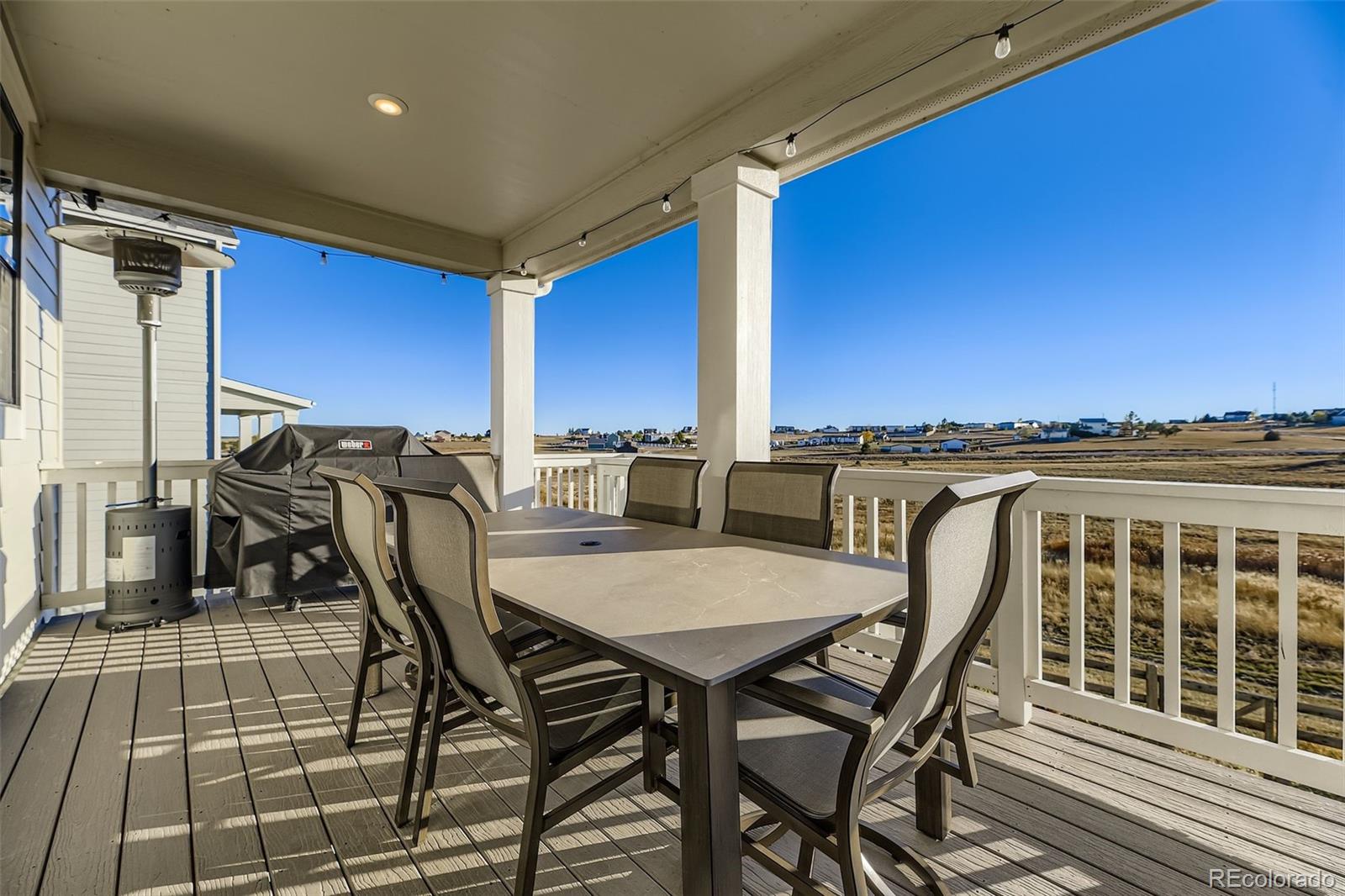 1126 Williams Loop Elizabeth, CO 80107 - Photo 36 of 50 a view of a patio with table and chairs with wooden floor and fence