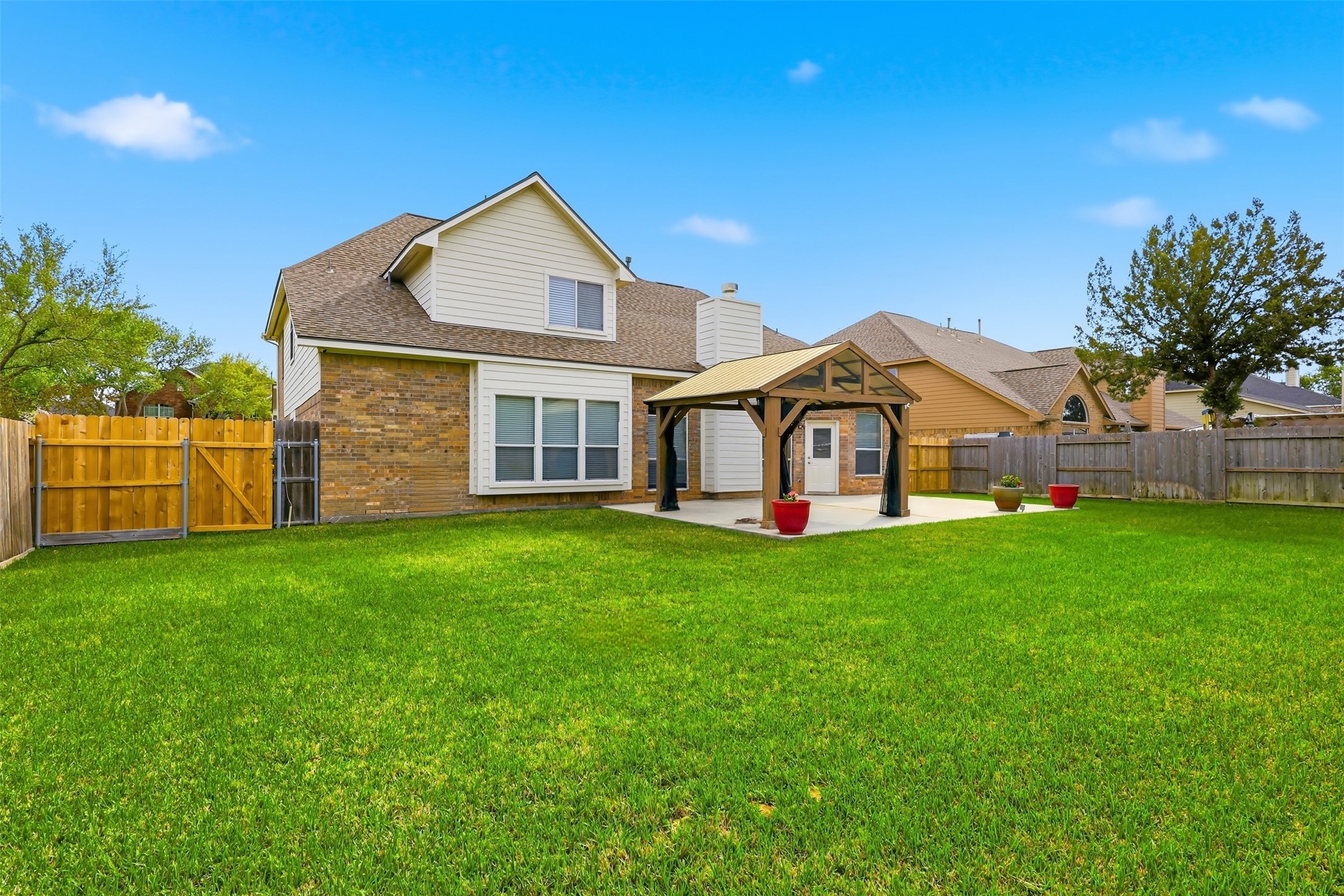 17406 North Riata Lake Cypress, TX 77433 - Photo 26 of 33 Rear exterior view highlighting the generous backyard, pergola-covered patio, and fully fenced outdoor space.
