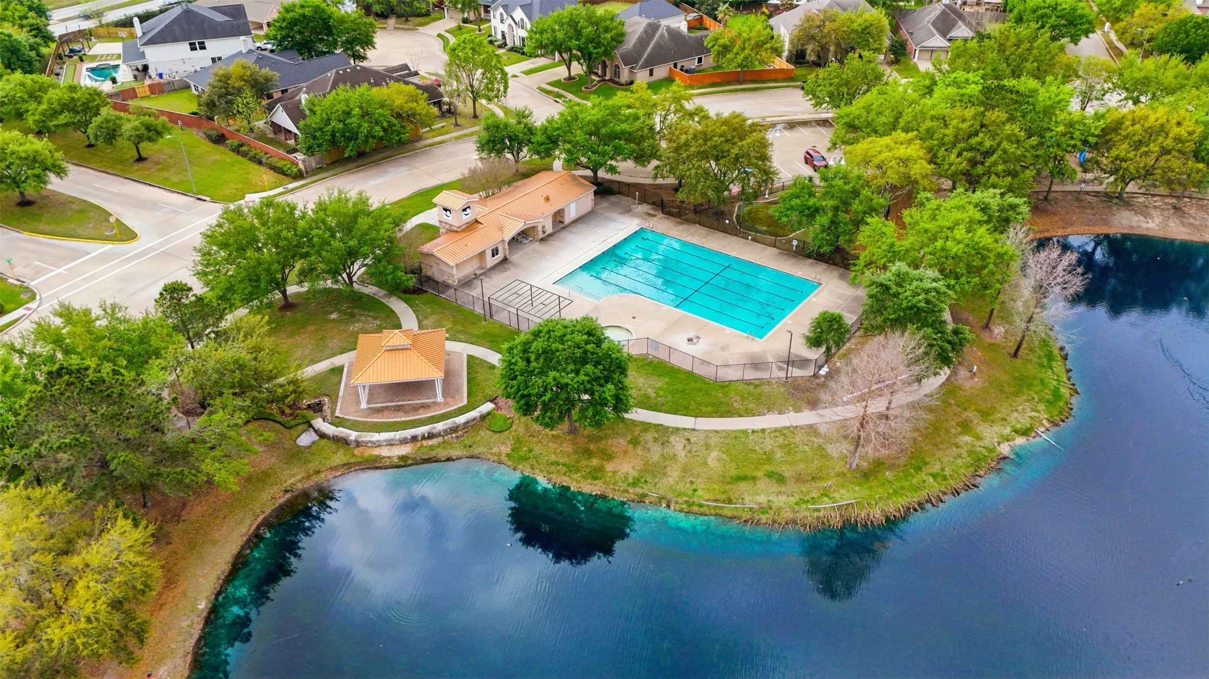17406 North Riata Lake Cypress, TX 77433 - Photo 28 of 33 Aerial view of the community pool and lakeside pavilion surrounded by walking paths and green space.