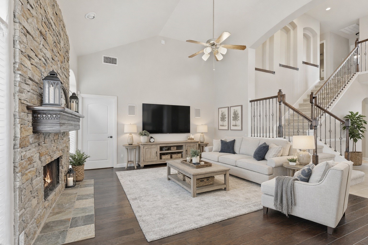 17406 North Riata Lake Cypress, TX 77433 - Photo 9 of 33 Spacious living room with soaring ceilings, a dramatic stone fireplace, and rich wood-look flooring (virtually staged).