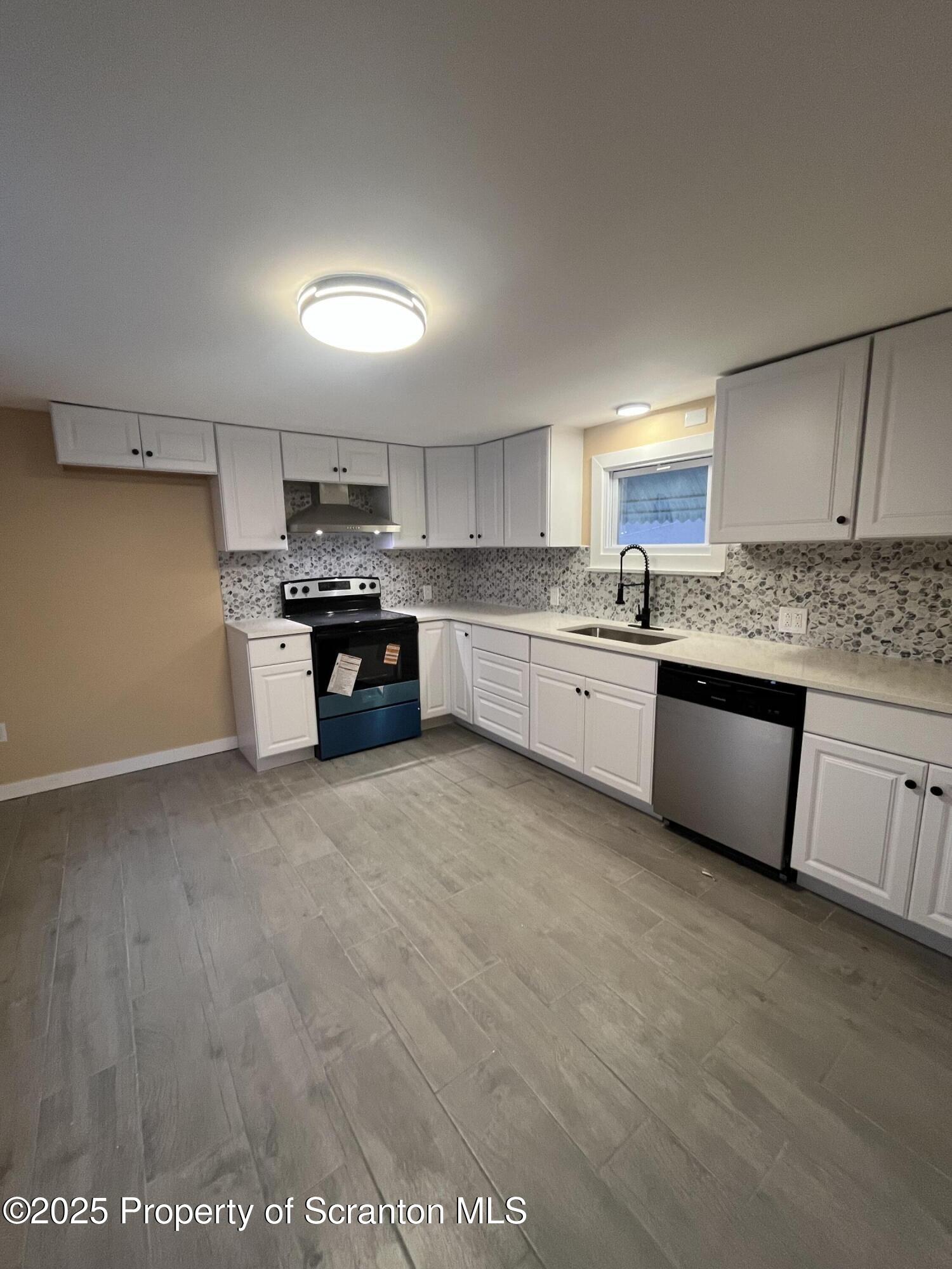 a large kitchen with kitchen island a sink stainless steel appliances and cabinets