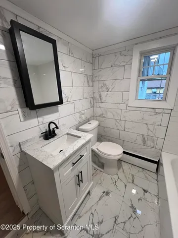 a bathroom with a toilet sink and mirror