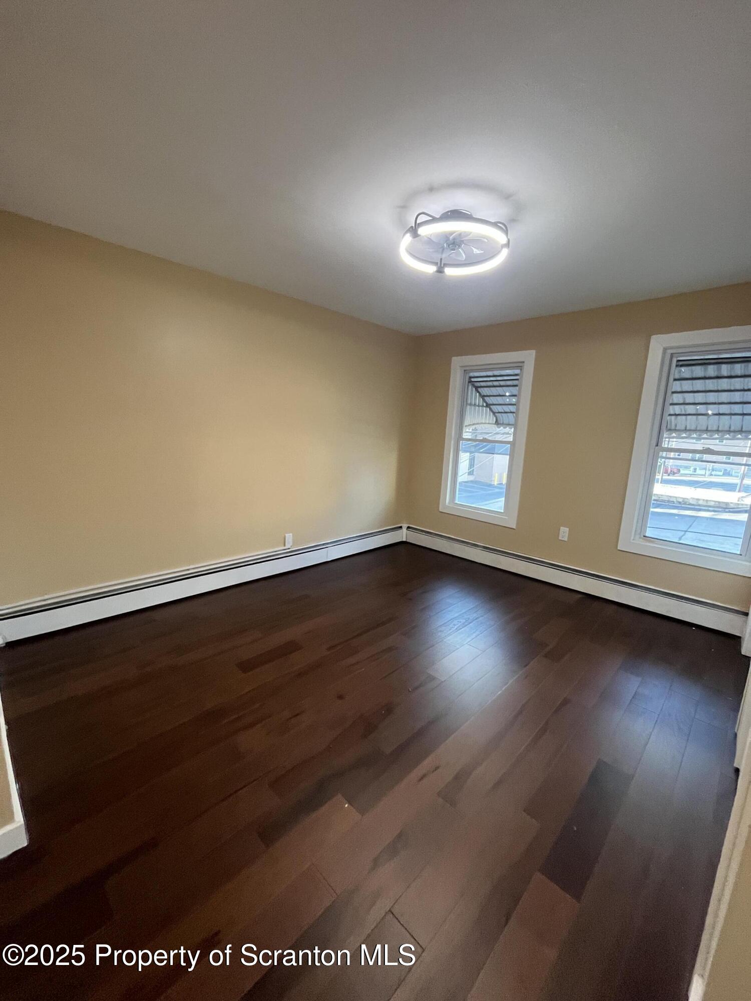 129 South Blakely Street, Unit 2 Dunmore, PA 18512 - Photo 9 of 10 an empty room with wooden floor and windows