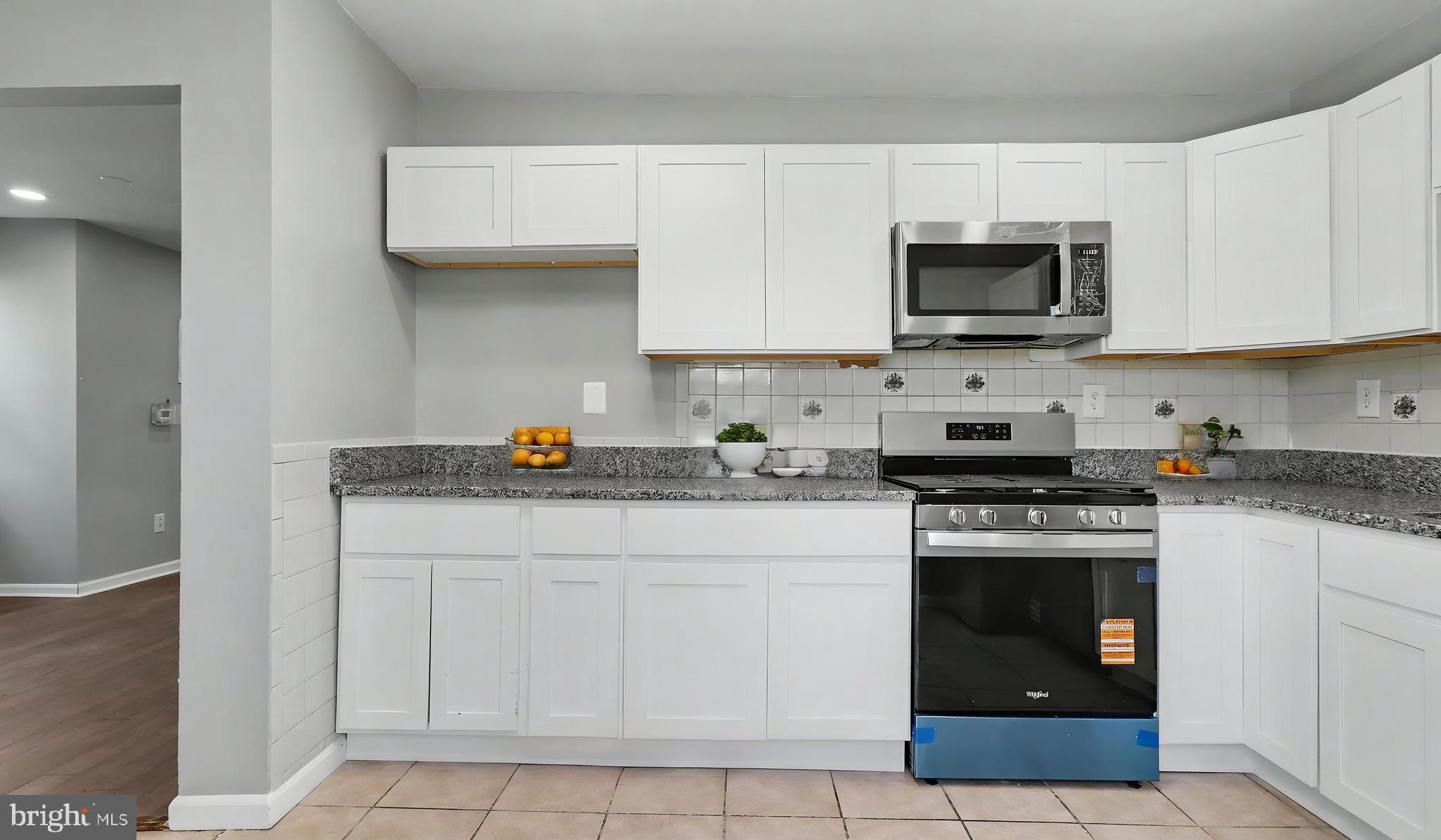 4203 Shell Street Capitol Heights, MD 20743 - Photo 35 of 47 a kitchen with stainless steel appliances granite countertop a stove a sink and a microwave