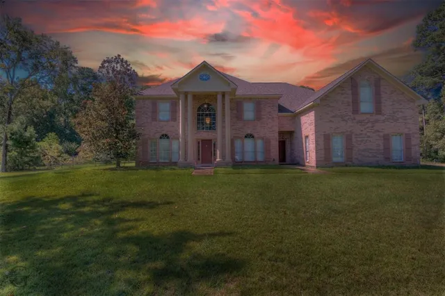 a view of a big house with a big yard and large trees