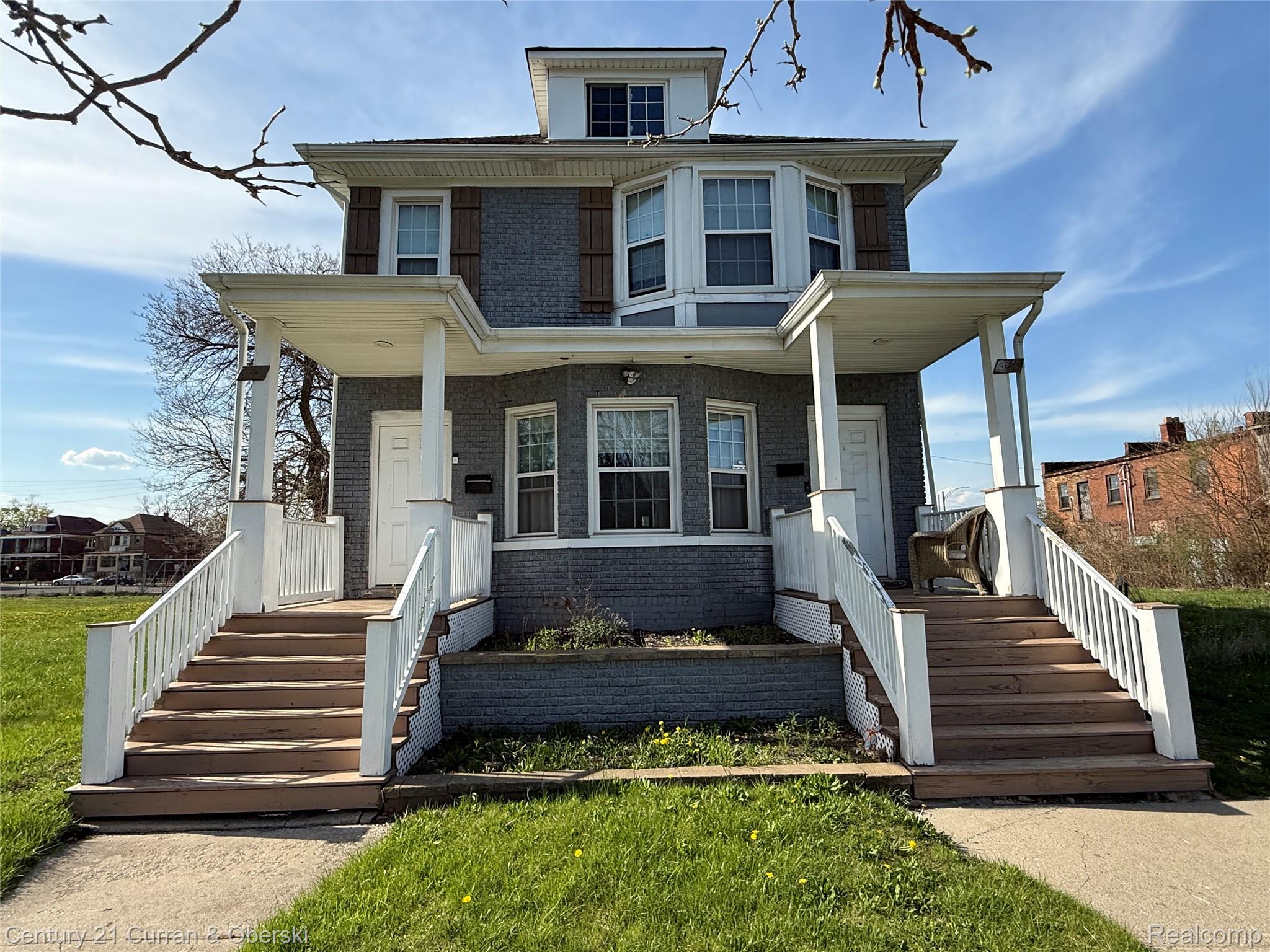 641 Josephine Street Detroit, MI 48202 - Photo 1 of 11 Multi-level gray brick facade featuring twin covered porches with white pillars and railings