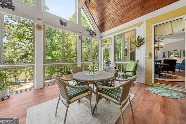 a living room with furniture a dining table and a floor to ceiling window