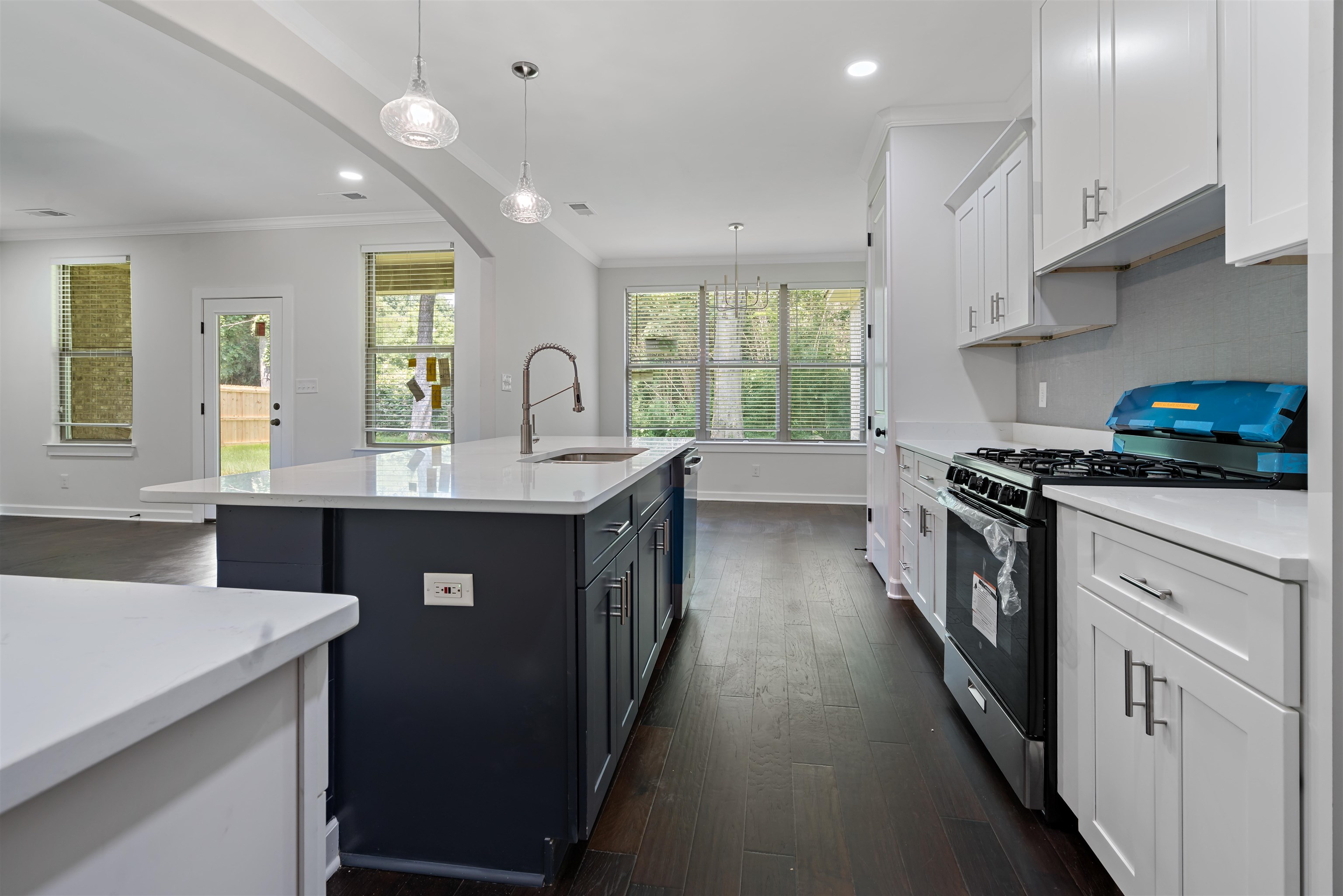694 Brownlee Road Memphis, TN 38116 - Photo 4 of 15 Kitchen with white cabinetry, dark hardwood / wood-style floors, gas range, pendant lighting, and sink
